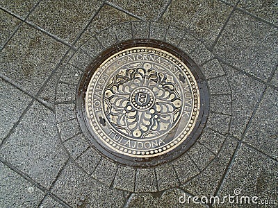 Sewer metal heavy hatch with ornament. Old historic street in the city center of Budapest, Hungary. Engineering urban systems. Editorial Stock Photo