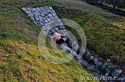Sewer pipes under the bridge. crossing ditch by side road. concrete hole Stock Photo