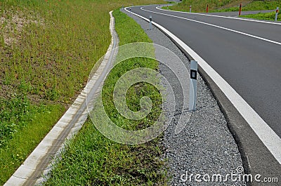 Sewer pipes under the bridge. crossing ditch by side road. concrete hole with stone paving surroundings. The gutter drains around Stock Photo