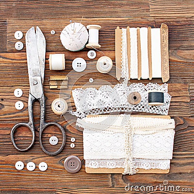 Sewing accessories in retro style on a brown wooden background. Stock Photo