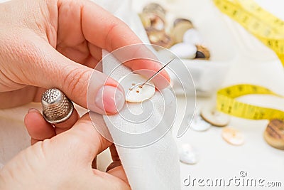 Sewing button on cloth Stock Photo