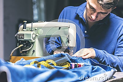 Sewing denim jeans with sewing machine. Repair jeans by sewing machine. Alteration jeans, hemming a pair of jeans, handmade Stock Photo