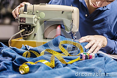 Sewing denim jeans with sewing machine. Repair jeans by sewing machine. Alteration jeans, hemming a pair of jeans, handmade Stock Photo