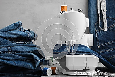 Sewing denim jeans on sewing machine in tailor work shop Stock Photo