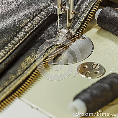 Sewing leather jacket repairing leather jacket scissors, thread, sewing machine, close-up Stock Photo