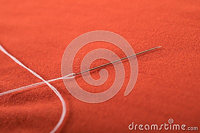 Sewing needle with white thread attached to it Stock Photo