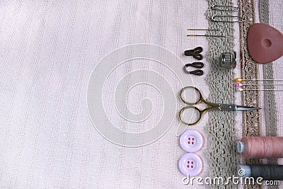 Sewing scene table flat lay side composition. Threads, lace, pins, scissors, tape, reel, cloth. Pastel colors linen Stock Photo