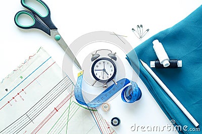 Sewing to order on time. Flat lay, top view, copy space. Blue fabric, watch, sewing tools and needlework accessories Stock Photo