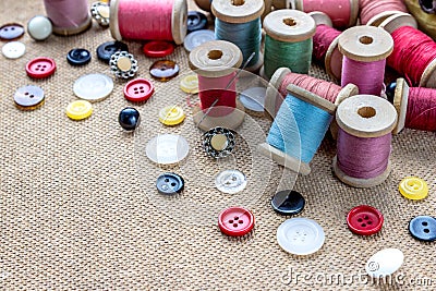 Sewing tools many different colorful thread, needle, many different buttons on wooden background Stock Photo