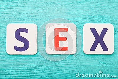 Sex word by letter blocks on blue wooden background. Top view. Copy space. Stock Photo