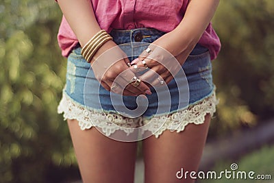 and attractive woman legs and hands, wearing casual denim shorts Stock Photo