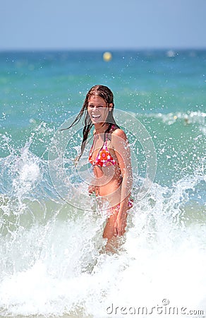 Attractive young girl being splashed by cold wave in the se Stock Photo