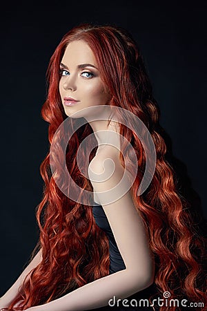 beautiful redhead girl with long hair. Perfect woman portrait on black background. Gorgeous hair and deep eyes Natural beauty Stock Photo