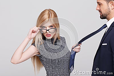 blonde manipulator woman pulling man by tie Stock Photo