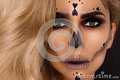 blonde woman in Halloween makeup and leather outfit on a black background in the studio. Skeleton, monster Stock Photo