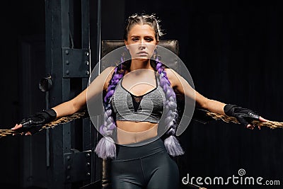 boxing girl stands leaned on ropes of competition ring. Stock Photo