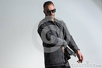 Sexy casual guy with sunglasses wearing only a grey denim jacket Stock Photo