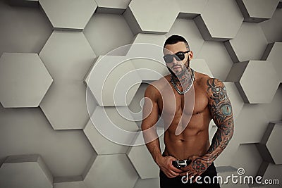 closeup topless portrait of Elegant handsome male model with fashion tattoo and a black beard standing and posing Stock Photo