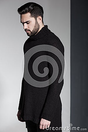 fashion man model in black sweater, jeans and boots posing dramatic Stock Photo