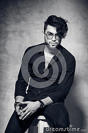 fashion man model dressed casual wearing glasses posing dramatic against grunge wall Stock Photo