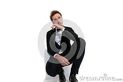 Sexy fashion model squatting, sensually touching his chin Stock Photo