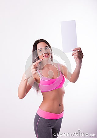 fitnes brunette in a tracksuit holding empty white board Stock Photo