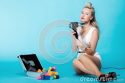 girl retro style in curlers with hairdryer styling hair Stock Photo