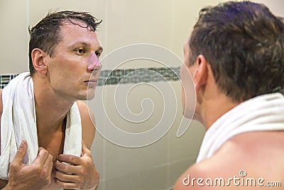 Sexy handsome young shaving and looking at himself Stock Photo