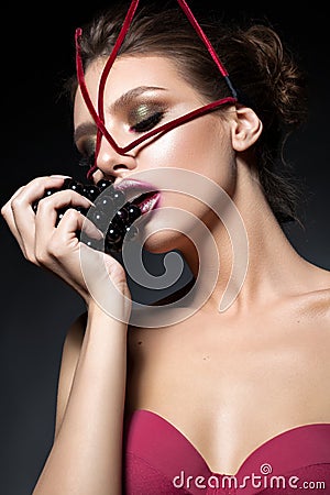 model with fashion makeup, unusual face accessory and dark grapes Stock Photo