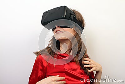 Sexy, mysterious woman in a red dress, wearing Oculus Rift VR Virtual reality 3D headset, intrigued Editorial Stock Photo