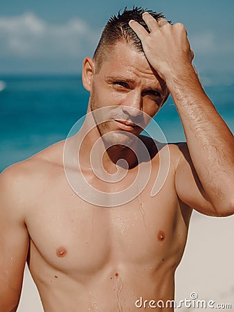Sexy portrait of handsome topless male model on the tropical beach Stock Photo