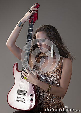 rocker girl in gold posing with electrical guitar Stock Photo