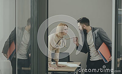 secretary seduce boss in office. Businesswoman on desktop look at bearded businessman. Man under woman domination Stock Photo