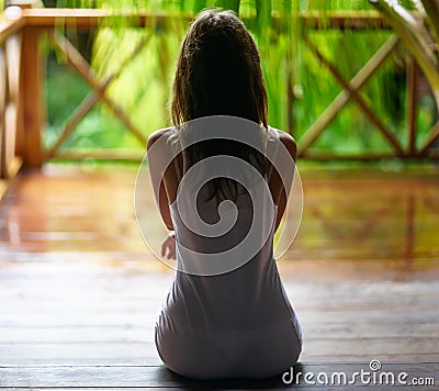 silhouette of a woman sitting on the porch during the rain. Stock Photo