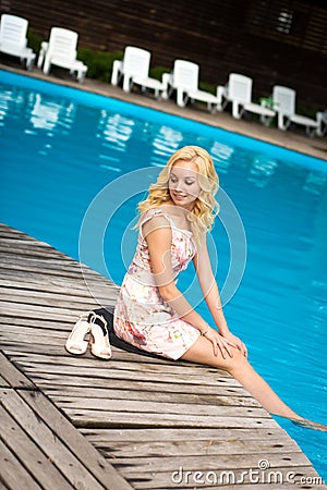Sexy slim gorgeous young blonde is relaxing by the pool in a luxury hotel Stock Photo