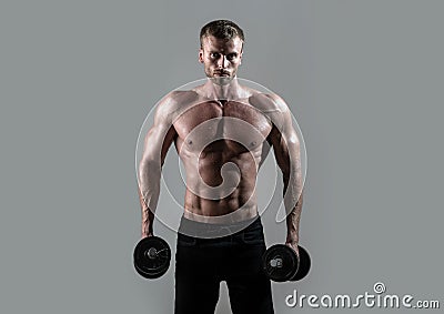 Sexy sporty torso, man with dumbbells. Muscular man working out in studio doing exercises, strong male naked torso abs. Stock Photo