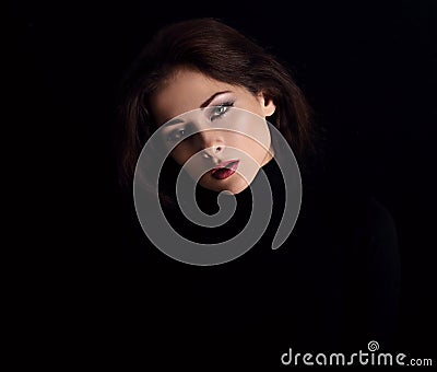 Sexy strong look woman with smirking smiling posing isolated on dark shadow black background. Closeup portrait in deep low key Stock Photo