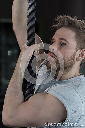 strongman climbing the rope Stock Photo