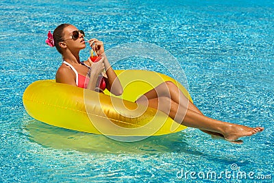 woman in bikini enjoying summer sun and tanning during holidays in pool with a cocktail Stock Photo