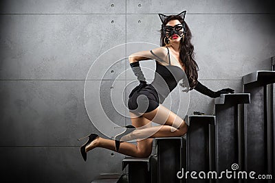 woman in catwoman suit lying on stairs Stock Photo