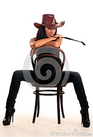 woman in cowboy hat sits on chair Stock Photo