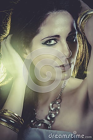 woman with gold and silver bracelets over golden light Stock Photo