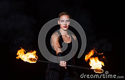 Sexy woman performer twirl burning baton during fire performance in dark night outdoors, partyin Stock Photo