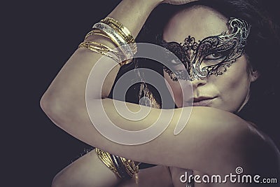 woman with venetian mask and gold and silver bracelets Stock Photo