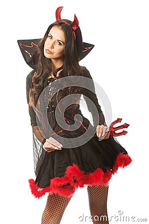 woman wearing devil clothes, standin astride, holding trident Stock Photo