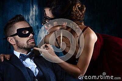 Rich man tempts woman in red evening dress Stock Photo