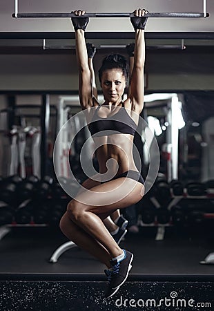 young fitness girl pulls up in the gym Stock Photo