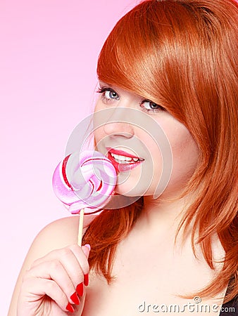 young woman holding candy. Redhair girl eating sweet lollipop Stock Photo