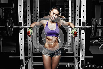 Young girl with perfect abs resting after squat exercises Stock Photo