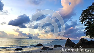 Peaceful Seychelles Beach Sunset with amazing sky and rocks. Stock Photo